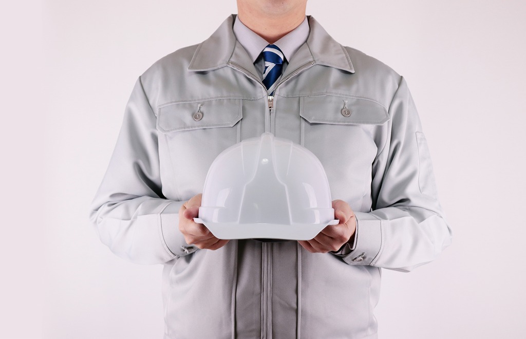 ヘルメットを持つ作業服の男性
